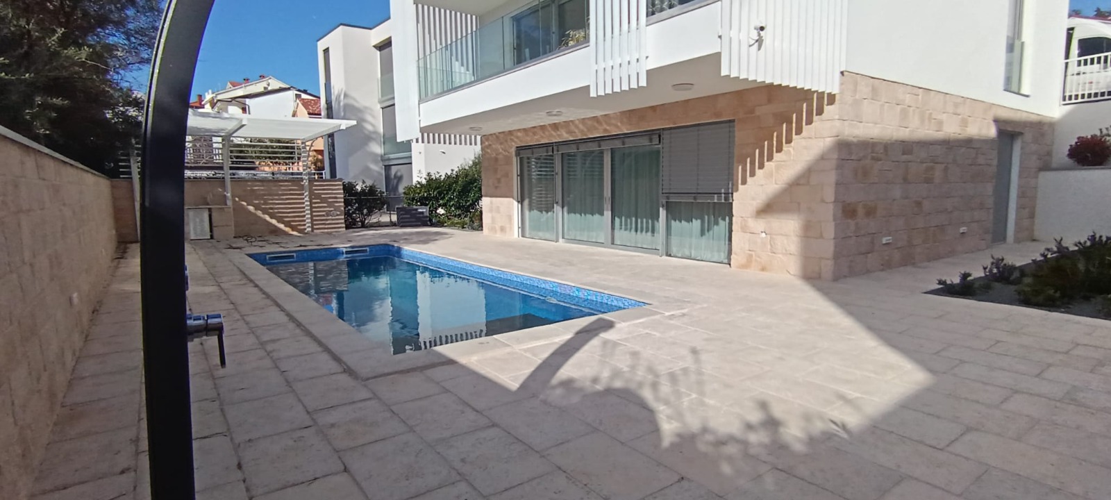 A photorealistic image of a condominium balcony overlooking the Adriatic Sea at sunrise. The balcony is furnished with comfortable seating and a small table. The sky is painted with vibrant colors, and the sea is calm and serene. The camera angle is a medium shot, capturing the balcony and the stunning view. The scene should evoke a sense of peace and tranquility. 4k resolution.